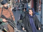 Taliban In Afghanistan News: A Taliban fighter stands guard as a woman walks past in Kabul, Afghanistan. (AP) Taliban In Afghanistan News: A Taliban fighter stands guard as a woman walks past in Kabul, Afghanistan. (AP)