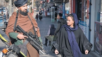 Taliban In Afghanistan News: A Taliban fighter stands guard as a woman walks past in Kabul, Afghanistan. (AP) Taliban In Afghanistan News: A Taliban fighter stands guard as a woman walks past in Kabul, Afghanistan. (AP)