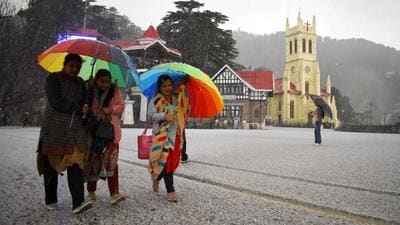 Women walk with their umbrellas amid hail storm on The Ridge in Shimla on Tuesday. (Deepak Sansta/HT)