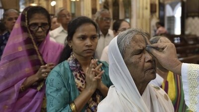 A Catholic priest marks the symbol of the cross with ash on the forehead of a devotee during an Ash Wednesday service. (Satish Bate / HT Photo) A Catholic priest marks the symbol of the cross with ash on the forehead of a devotee during an Ash Wednesday service. (Satish Bate / HT Photo)