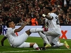 Real Madrid's Brazilian forward Vinicius Junior (R) celebrates scoring the team's second goal with Rodrygo (C) and Eder Militao during the UEFA Champions League mattch against Liverpool