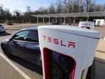 A driver recharges the battery of his Tesla car.