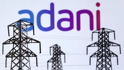 Electric power transmission pylon miniatures and Adani Green Energy logo are seen in this illustration taken, December 9, 2022. REUTERS/Dado Ruvic