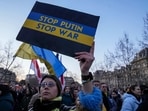 A Ukrainian supporter holds a placard to mark the one-year anniversary of the full-scale Russian invasion of Ukraine during a gathering at Place de la Republique in Paris, A Ukrainian supporter holds a placard to mark the one-year anniversary of the full-scale Russian invasion of Ukraine during a gathering at Place de la Republique in Paris,