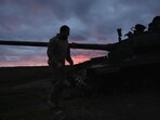 Russia-Ukraine War: A Ukrainian serviceman walks near a destroyed tank at sunset, as Russia's invasion of Ukraine continues, near Izium, Ukraine.