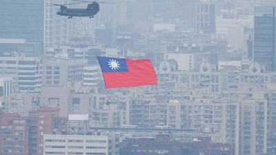 China-Taiwan Conflict: A Chinook helicopter carrying a Taiwan flag flies over the city during the country's National Day celebration in Taipei, Taiwan. (Reuters)