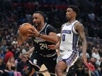 LA Clippers forward Norman Powell (24) is defended by Sacramento Kings guard Malik Monk (0) in the second half at Crypto.com Arena. The Kings defeated the Clippers 176-175 in double overtime.