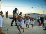 Handout picture released by the Press Secretary of the Presidency of El Salvador showing police officers keeping watch during the arrival of inmates belonging to the MS-13 and 18 gangs to the new prison "Terrorist Confinement Centre" (CECOT), in Tecoluca, 74 km southeast of San Salvador, on February 24, 2023.
