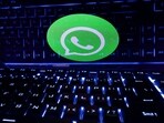 A keyboard is placed in front of a displayed WhatsApp logo in this illustration.
