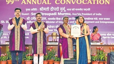 Delhi University vice-chancellor Yogesh Singh, Union education minister Dharmendra Pradhan applaud as President Droupadi Murmu confers a degree on a student at the 99th convocation ceremony on Saturday. (Raj K Raj/HT PHOTO) Delhi University vice-chancellor Yogesh Singh, Union education minister Dharmendra Pradhan applaud as President Droupadi Murmu confers a degree on a student at the 99th convocation ceremony on Saturday. (Raj K Raj/HT PHOTO)