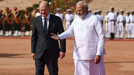 PM Modi walks with German Chancellor Olaf Scholz during his ceremonial reception at India's presidential palace Rashtrapati Bhavan in New Delhi on Friday.(AFP)