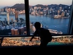 A child plays in front of skyline buildings, in Hong Kong, China. Hong Kong airline worker shortage hits city’s push to reopen after years of closed borders 
