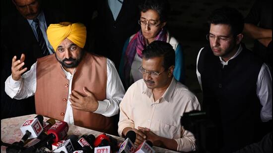 Delhi chief minister Arvind Kejriwal and Punjab chief minister Bhagwant Mann address media persons outside Delhi deputy chief minister Manish Sisodia’s residence in New Delhi on Sunday. (Vipin Kumar/HT Photo)