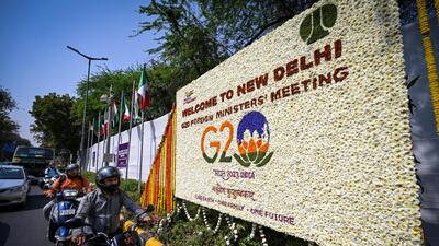 A board decorated with flowers for welcoming G20 delegates is being placed at Sardar Patel Marg in New Delhi, India, on Tuesday. (Sanchit Khanna/ Hindustan Times)