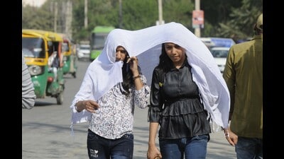 Girls cover their faces with scarf on a hot day in Gurugram on February 27. (Parveen Kumar/HT) Girls cover their faces with scarf on a hot day in Gurugram on February 27. (Parveen Kumar/HT)