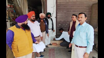 MC officials outside a shop sealed for non-payment of property tax in Ludhiana on Tuesday. (Gurpreet Singh/HT Photo) MC officials outside a shop sealed for non-payment of property tax in Ludhiana on Tuesday. (Gurpreet Singh/HT Photo)