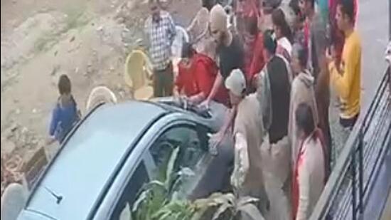 A CCTV grab showing the woman being dragged on car bonnet in Ekta Vihar Colony of Baltana on Tuesday. (HT Photo)