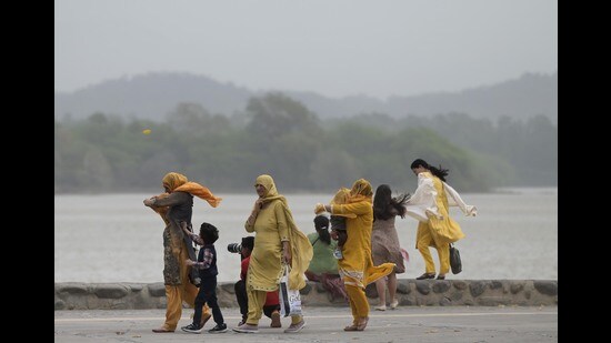 Visitors brave dust at Sukhna Lake in Chandigarh on Tuesday. (Ravi Kumar/HT)