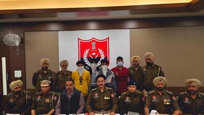 Patiala senior superintendent of police Varun Sharma (centre) with his team addressing a press conference on Wednesday after the arrest of all four accused (masked). (HT Photo)