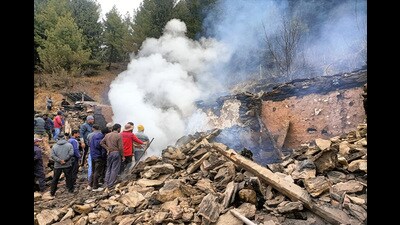 People gather around the fire site on Tuesday. (HT Photo)