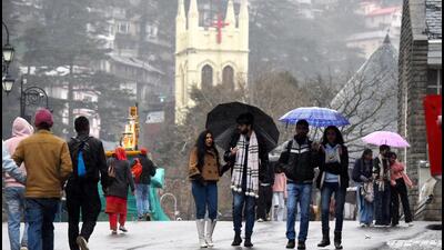 People take a stroll amid drizzle on The Ridge in Shimla on Tuesday. (Deepak Sansta/HT)