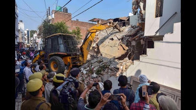 Prayagraj Development Authority bulldozer demolishes properties of the Umesh Pal murder case accused, who were close aides of Atiq Ahmad, in the Chakiya area, in Prayagraj on Wednesday. (PTI) Prayagraj Development Authority bulldozer demolishes properties of the Umesh Pal murder case accused, who were close aides of Atiq Ahmad, in the Chakiya area, in Prayagraj on Wednesday. (PTI)