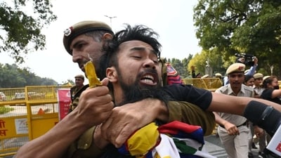 Police official dragging a protestor while taking control of the situation.&nbsp; (Vipin Kumar/ Hindustan Times)