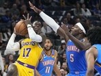 Los Angeles Lakers guard Dennis Schroder (17) drives to the basket past Oklahoma City Thunder guard Luguentz Dort (5) in the second half of an NBA basketball game. Los Angeles Lakers guard Dennis Schroder (17) drives to the basket past Oklahoma City Thunder guard Luguentz Dort (5) in the second half of an NBA basketball game.