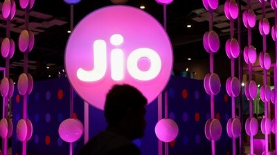 A man walks across the LED board showing the logo of Jio (REUTERS)
