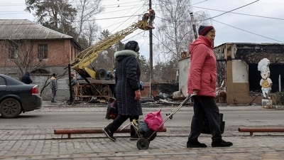 Local residents charge their devices in a rural outpatient clinic, equipped with a generator and satellite internet due to lack of electricity, in the village of Dubivka, Kharkiv region, on March 1, 2023, amid the Russian invasion of Ukraine. (AFP)