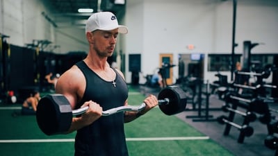 Barbell Bicep Curl: This classic exercise is one of the best for building bicep muscle. Start by standing with your feet shoulder-width apart and holding a barbell in front of your thighs with an overhand grip. Keeping your elbows close to your body, curl the barbell up until your forearms touch your biceps. Slowly lower the barbell back to the starting position. (Unsplash)