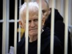 Ales Bialiatski, the head of Belarusian Vyasna rights group, sits in a defendants' cage during a court session in Minsk, Belarus