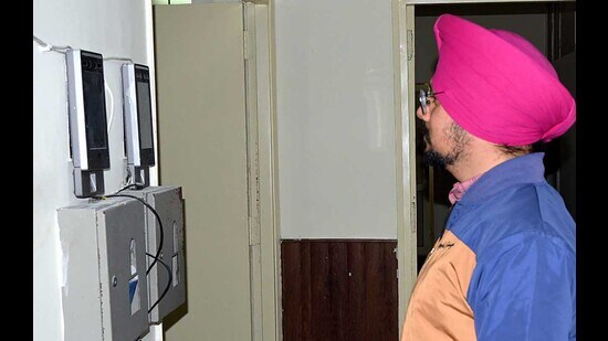 MC staff marking attendance through facial recognition machines installed in the MC offices in Ludhiana on Friday. (HT Photo)