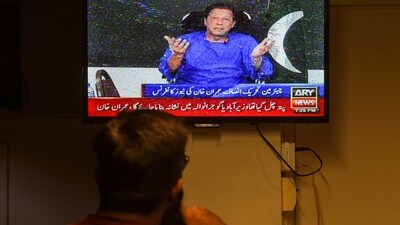 A man watches a television channel broadcasting the address of Pakistan former prime minister Imran Khan. (AFP) A man watches a television channel broadcasting the address of Pakistan former prime minister Imran Khan. (AFP)