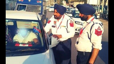 Traffic police personnel while checking an unauthorised police tag on a vehicle in Ludhiana on Sunday. (HT Photo) Traffic police personnel while checking an unauthorised police tag on a vehicle in Ludhiana on Sunday. (HT Photo)