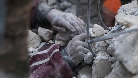 Turkey Earthquake: A rescue worker digs to reach a boy under the rubble. (AFP)