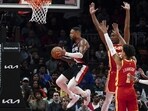 Portland Trail Blazers guard Damian Lillard, left, goes between Atlanta Hawks' De'Andre Hunter (12) and Jalen Johnson (1) during the first half of an NBA basketball game Friday, March 3, 2023, in Atlanta. Portland Trail Blazers guard Damian Lillard, left, goes between Atlanta Hawks' De'Andre Hunter (12) and Jalen Johnson (1) during the first half of an NBA basketball game Friday, March 3, 2023, in Atlanta.