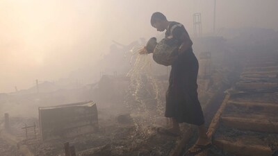 A Rohingya refugee seen trying to douse a major fire at the Balukhali camp in Ukhiya. The fire broke out around 2:45pm at camp number 11 in Kutupalong, one of the world's largest refugee settlements, and rapidly engulfed the bamboo-and-tarpaulin shelters, Mijanur Rahman, Bangladesh's refugee commissioner, told AFP.&nbsp; (Mahmud Hossain Opu / AP)