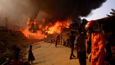 Fire officials try to douse the fire that overtook the camp on Sunday. While the blaze was brought under control in less than three hours, it was not clear how the fire started. The authorities have ordered an investigation. &nbsp; (Mahmud Hossain Opu / AP)