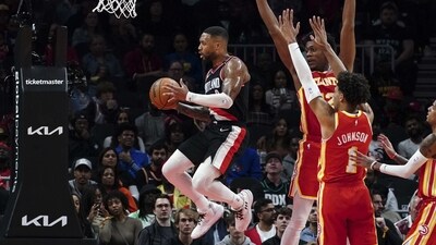 Portland Trail Blazers guard Damian Lillard, left, goes between Atlanta Hawks' De'Andre Hunter (12) and Jalen Johnson (1) during the first half of an NBA basketball game Friday, March 3, 2023, in Atlanta. (AP)