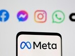 The Meta logo on smartphone in front of logo of Facebook, Messenger, Instagram, WhatsApp.