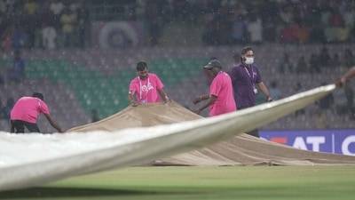 Ground staff run to cover the pitch as it rains during the 2023 Women's Premier League (WPL) match between UP Warriorz and Delhi Capitals (PTI)