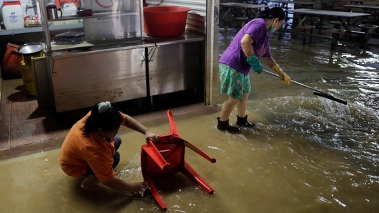 Hawkers clean their stall at a food court, as the floodwaters recede. Prime Minister Anwar Ibrahim visited flood victims on Sunday in Johor and vowed to speed up flood mitigation projects in the state, reports AP.&nbsp;(Hasnoor Hussain / Reuters)