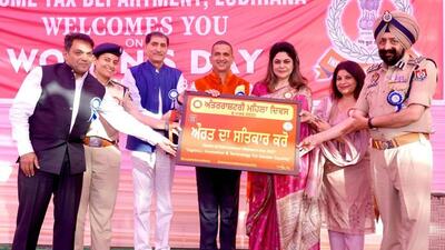 Income tax and police officials during the launch of the portrait dedicated to International Women Day, prepared by author and nature artist Harpreet Sandhu (centre). (HT Photo)