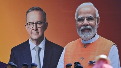 Police personnel stand next to a poster with the pictures of Australia's Prime Minister Anthony Albanese (L) and Indian Prime Minister Narendra Modi at the Narendra Modi stadium in Ahmedabad on March 7, 2023. (AFP)