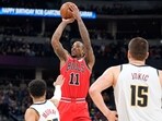 Chicago Bulls forward DeMar DeRozan, back, goes up for a basket over Denver Nuggets guard Jamal Murray, front left, and center Nikola Jokic in the second half of an NBA basketball game Wednesday, Chicago Bulls forward DeMar DeRozan, back, goes up for a basket over Denver Nuggets guard Jamal Murray, front left, and center Nikola Jokic in the second half of an NBA basketball game Wednesday,
