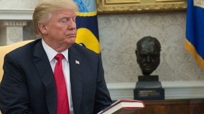 US President Donald Trump looks at a book given to him by a North Korean defector in the Oval Office at the White House in Washington, DC. (AFP) US President Donald Trump looks at a book given to him by a North Korean defector in the Oval Office at the White House in Washington, DC. (AFP)