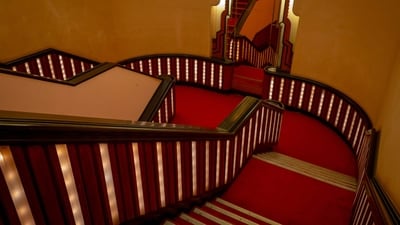 The staircase, the lobbies, the woodwork, the relief work on the ceilings, all lovingly lit by concealed bulbs, along with the plush red carpeting, create a vision of soft opulence at Liberty, in Mumbai.&nbsp; (Hemant Chaturvedi)