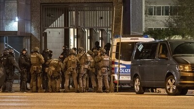 Television footage showed dozens of police cars as well as fire engines blocking off streets and some people, wrapped in blankets, being led by emergency service workers into a bus. (AP) Television footage showed dozens of police cars as well as fire engines blocking off streets and some people, wrapped in blankets, being led by emergency service workers into a bus. (AP)