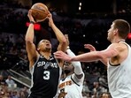 San Antonio Spurs forward Keldon Johnson (3) drives to the basket against Denver Nuggets guard Reggie Jackson (7) and center Nikola Jokic (15) during the first half at AT&T Center. 